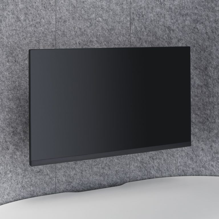 Black wall-mounted TV screen on a gray textured wall above a curved white surface