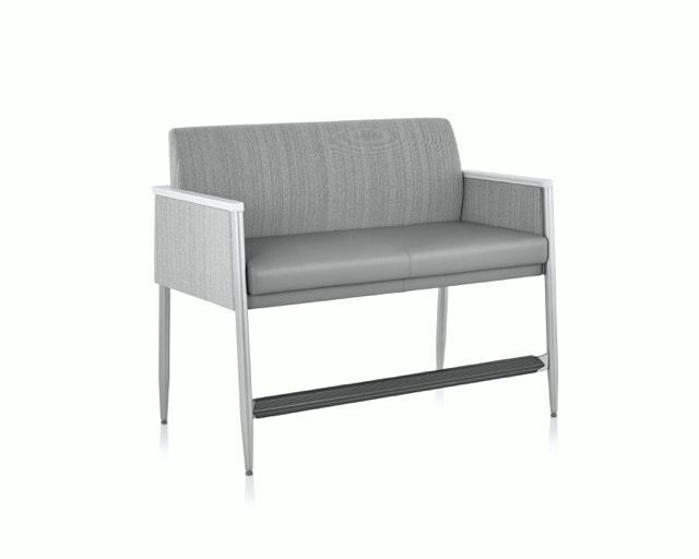 Gray upholstered two-seat sofa with light wood legs on a white background