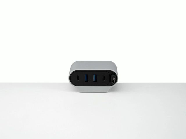 Small black and gray electronic device with blue indicators on a white surface