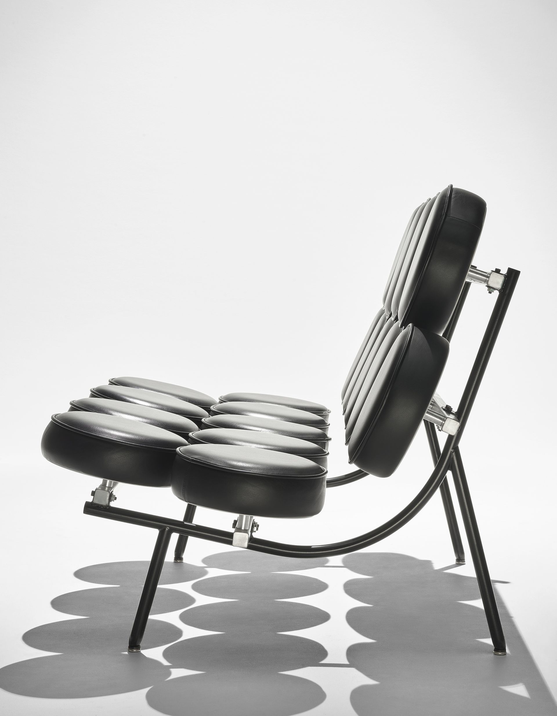 Black ergonomic chair with ribbed seat and back, shown in side view on a white background.
