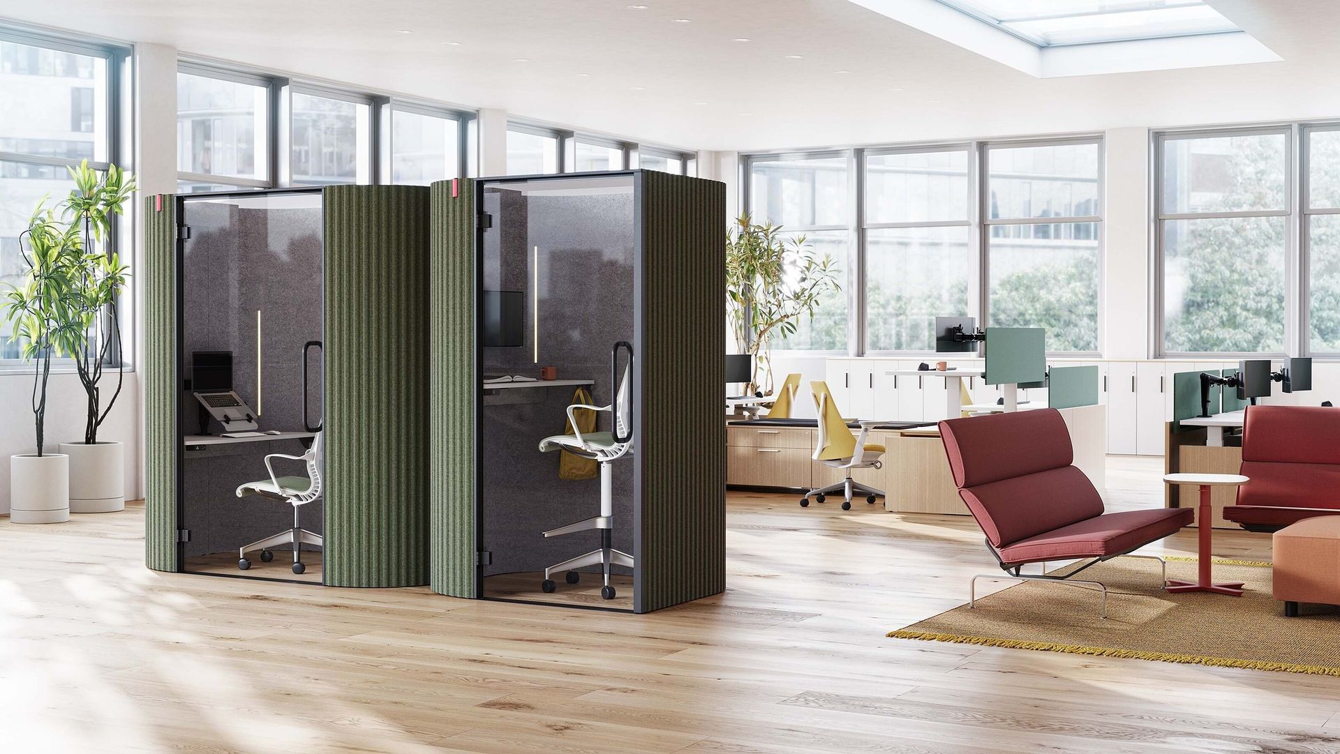 Modern office lounge with glass meeting pods, red chairs, wooden floor, and large windows