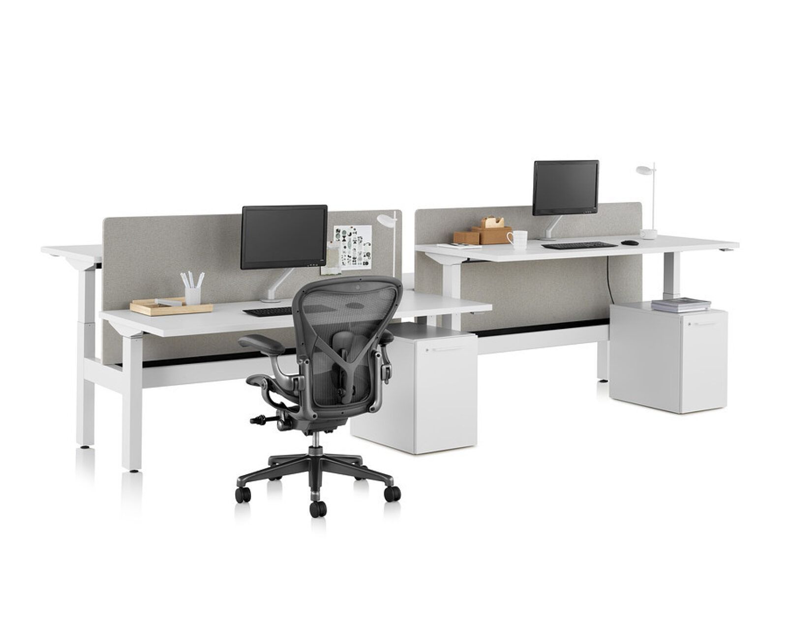 Modern shared office desk setup with two monitors, chairs, and storage cubes on a white background