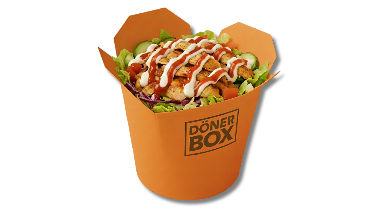 Hähnchen-Döner-Kebab-Salat in einer orangefarbenen Schachtel, mit Soße beträufelt.