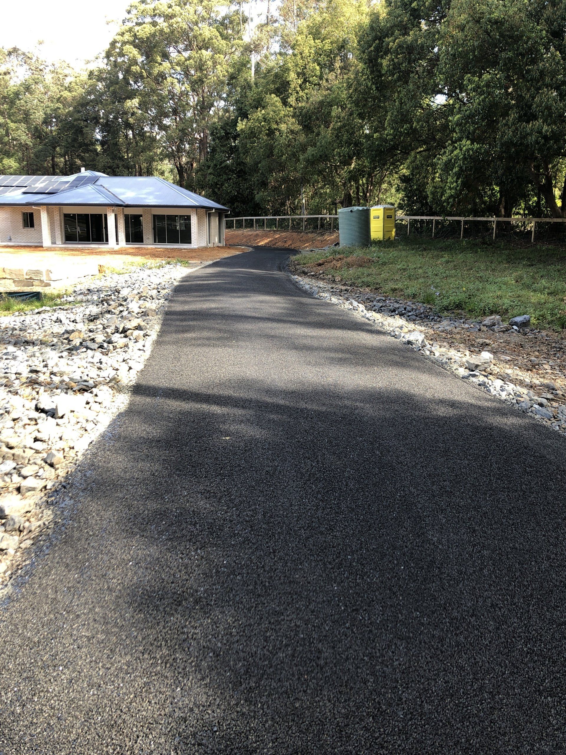 A road with a house in the background is being built.