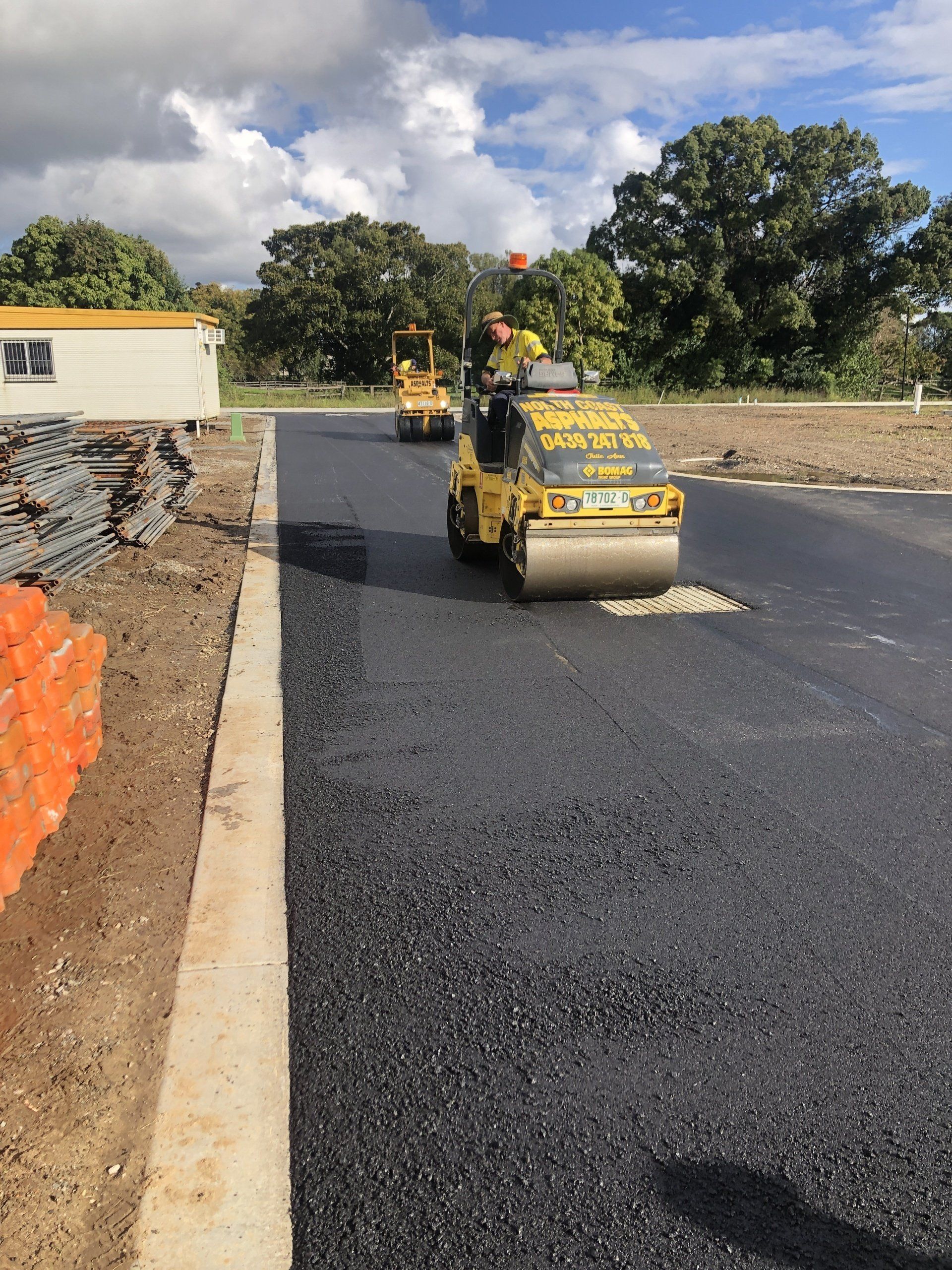 A group of construction vehicles are working on a road.