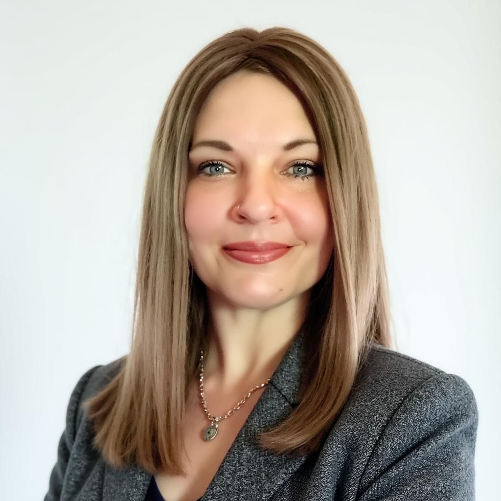 A woman wearing a black sweater and earrings is smiling for the camera.