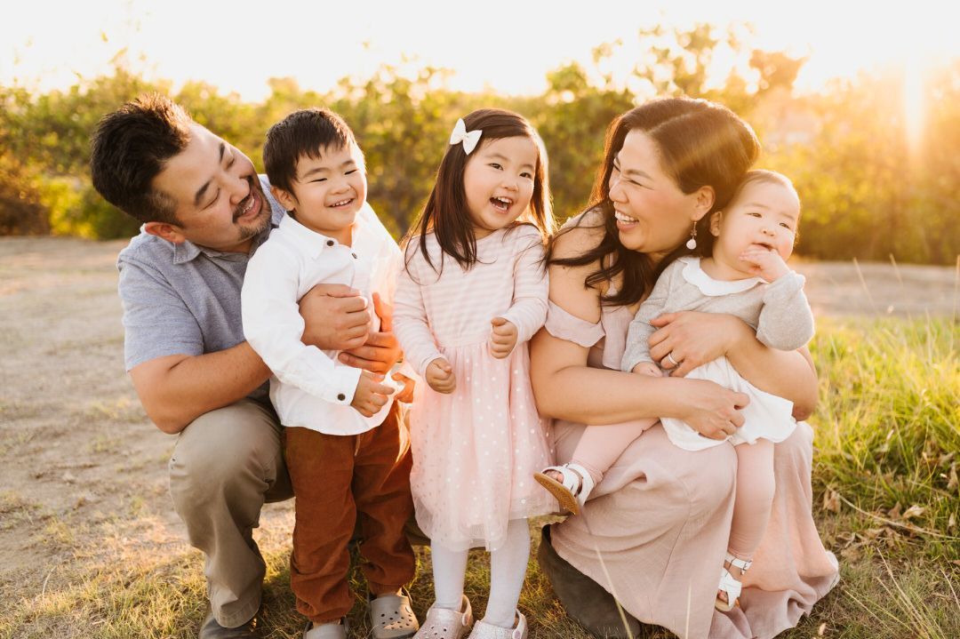 A family is posing for a picture together in a field.