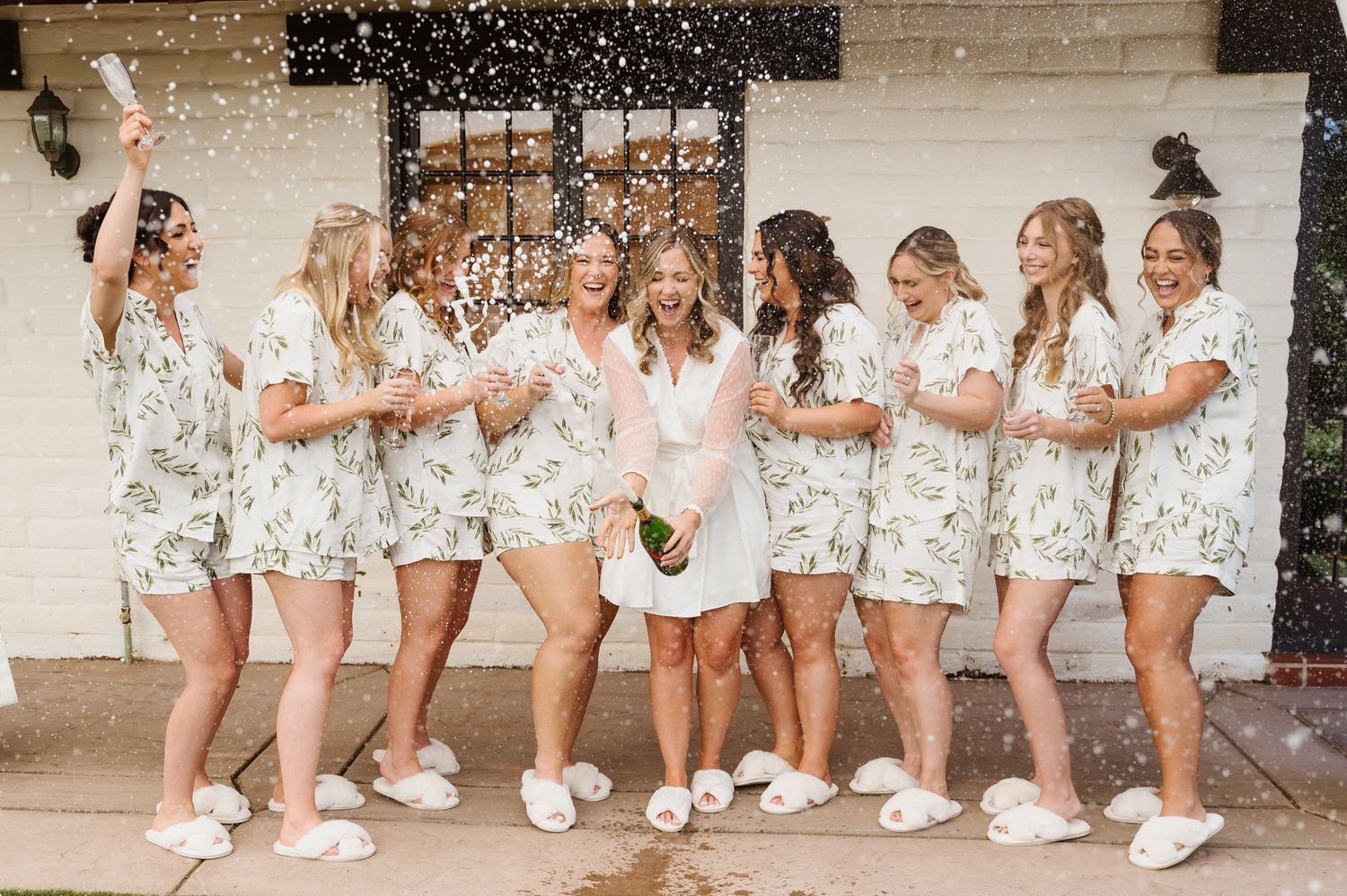 A bride and her bridesmaids are posing for a picture in front of a building.