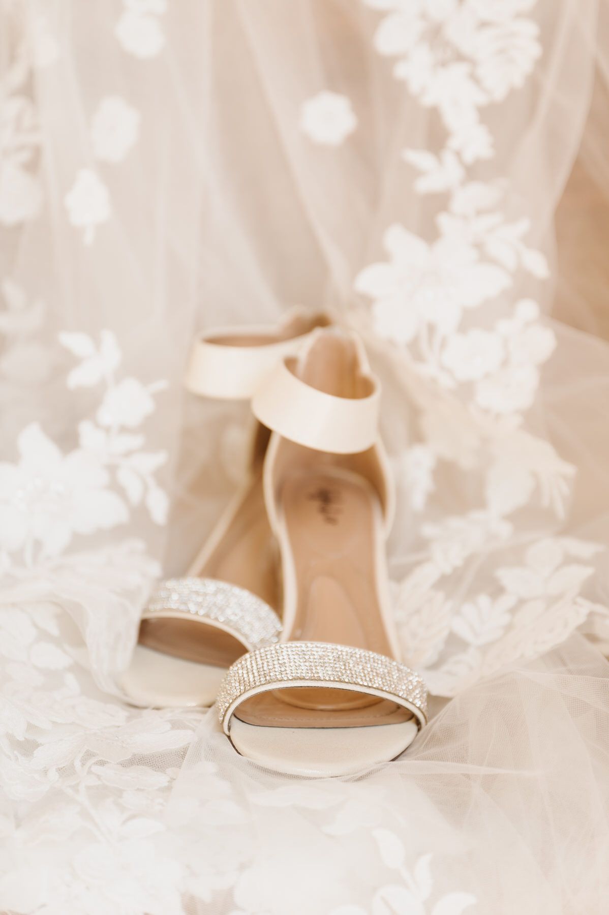 A pair of wedding shoes sitting on top of a wedding dress.