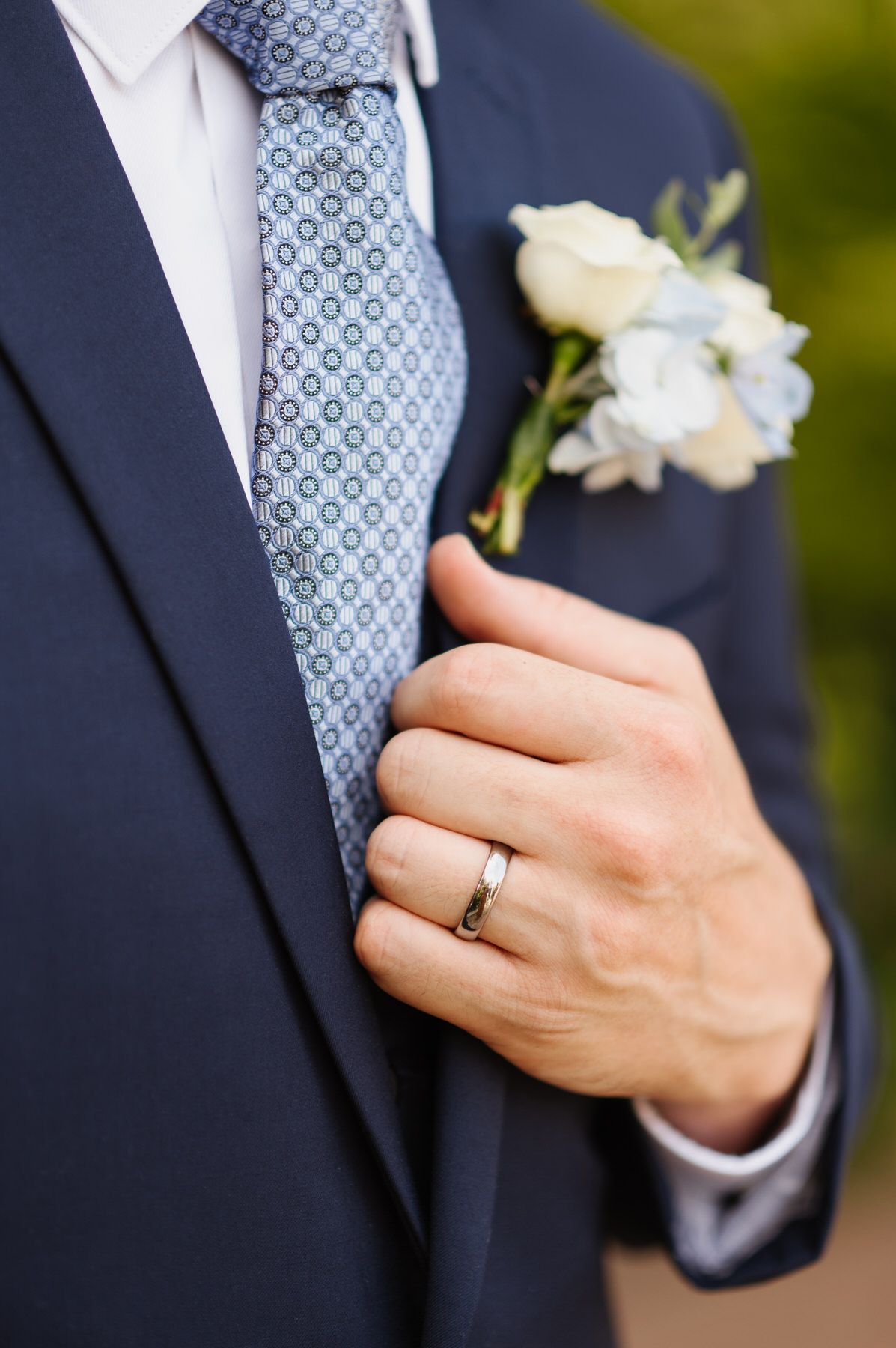 A man in a suit has a ring on his finger