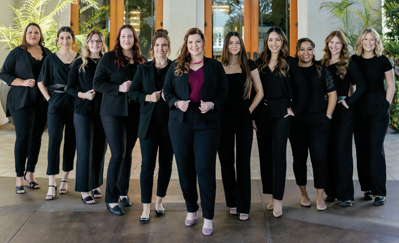 A bride and her bridesmaids are posing for a picture in front of a brick building.