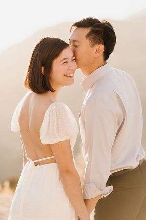 A man is kissing a woman on the forehead.