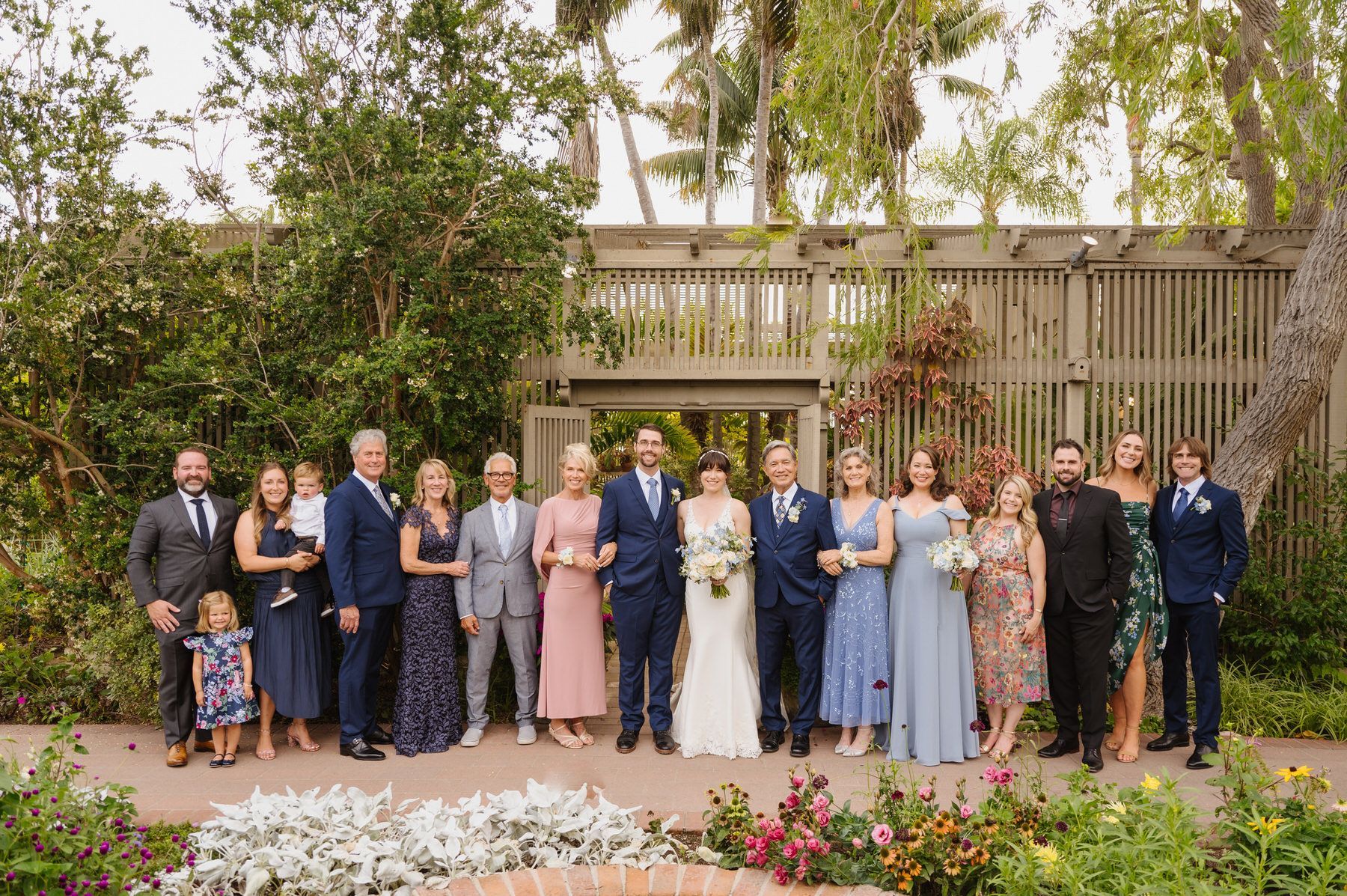 A large group of family members are posing for a picture at a wedding.