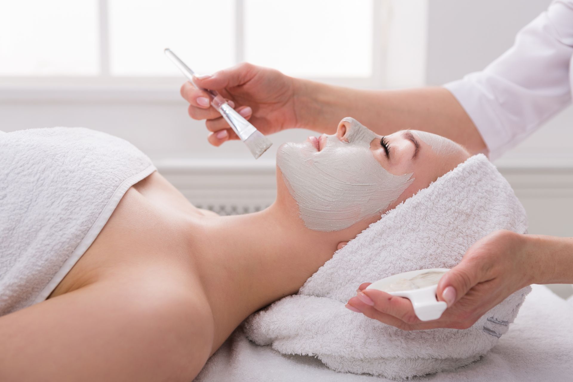 A woman is getting a facial treatment at a spa.