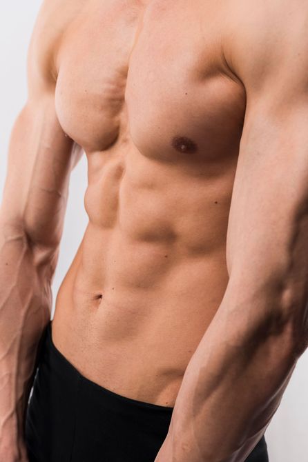 A close up of a man 's torso and arms without a shirt on.