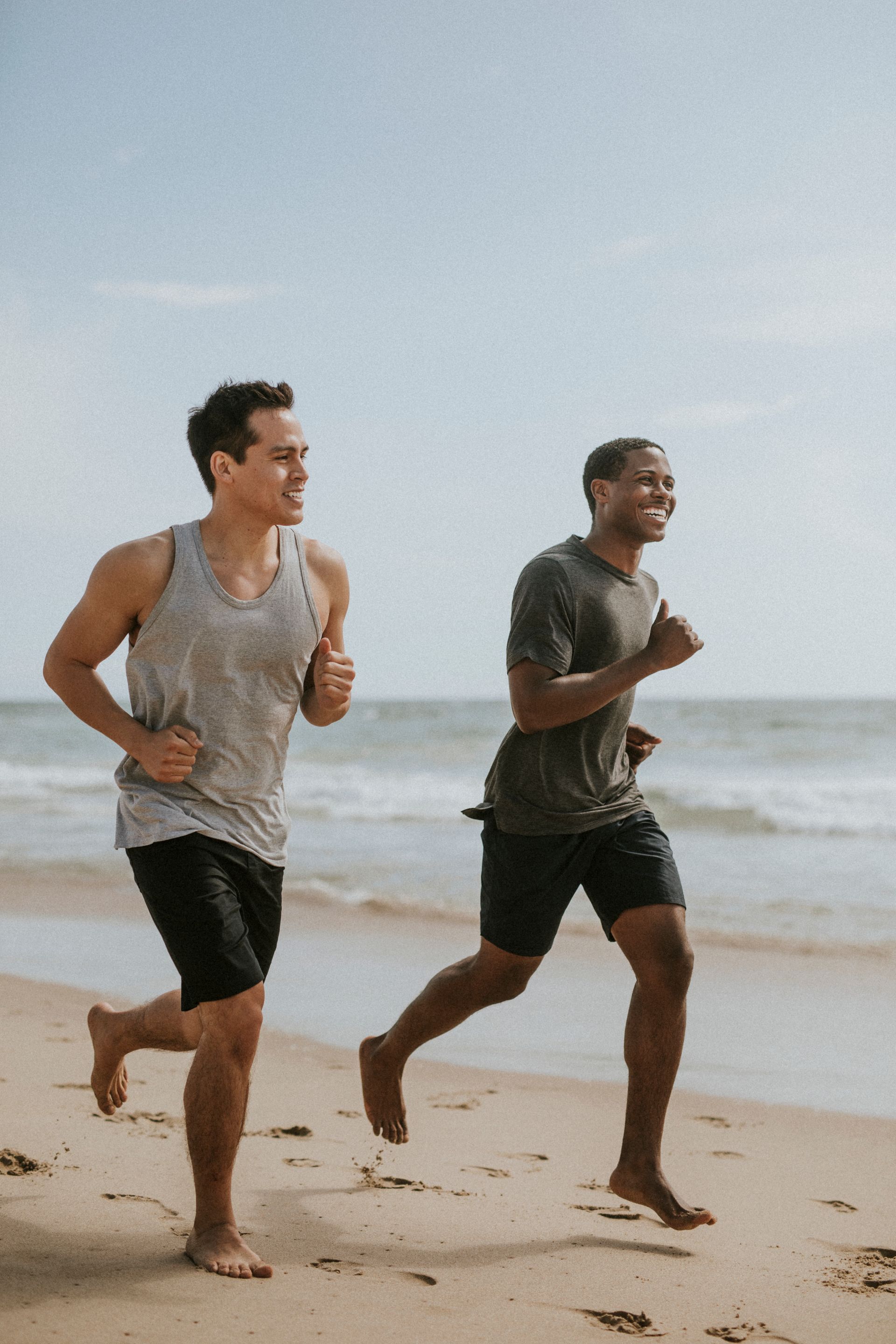 Two men are running on the beach.