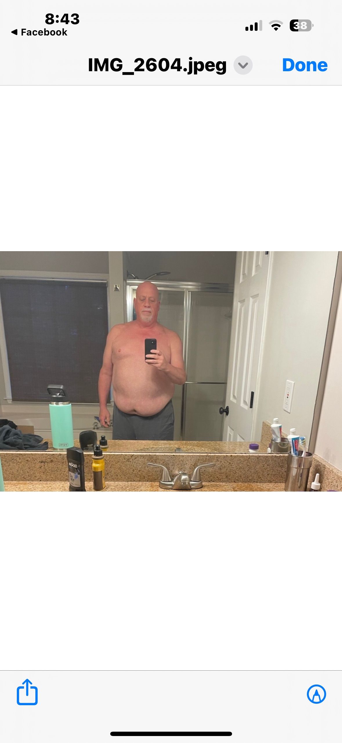 A man is taking a selfie in front of a bathroom mirror.