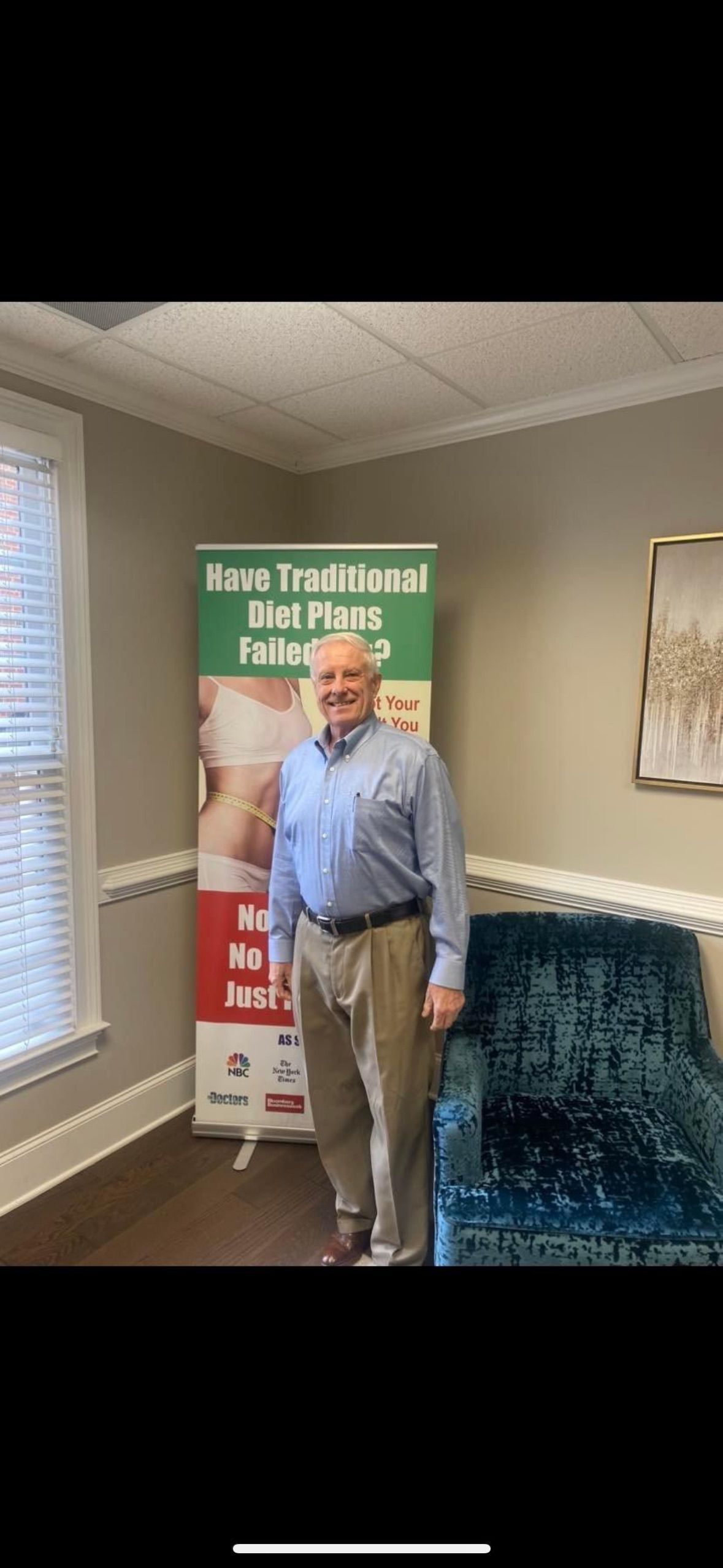 A man is standing in a room in front of a sign.