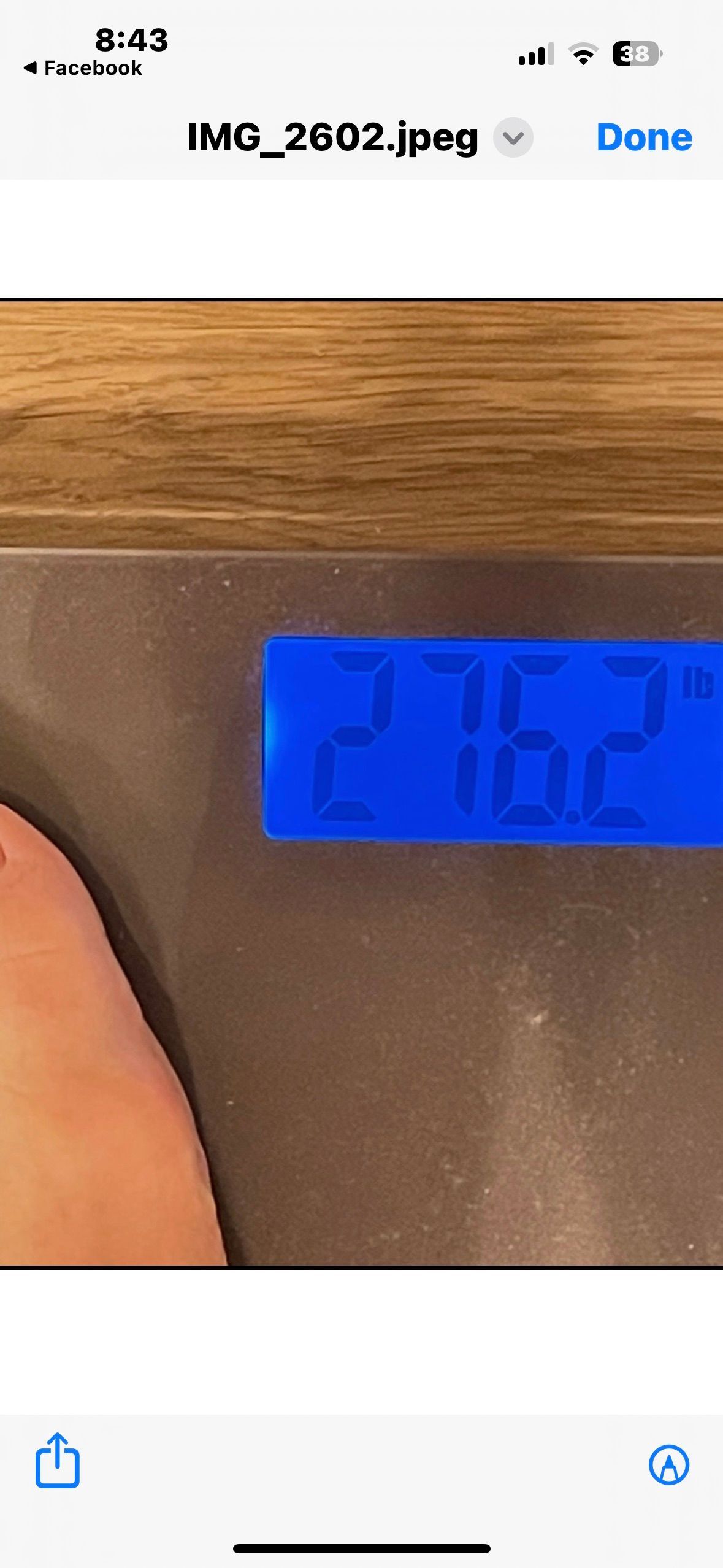 A phone screen shows a person 's weight on a scale.