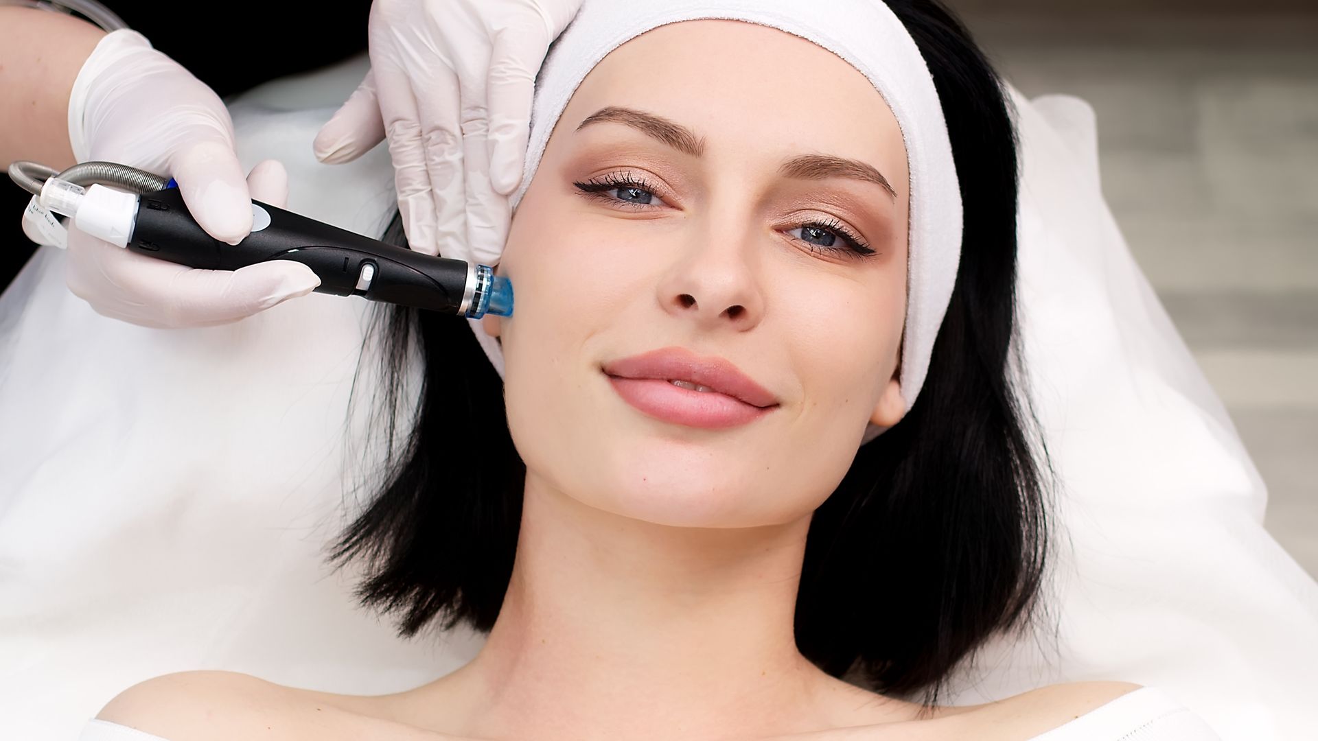 A woman is getting a facial treatment at a beauty salon.