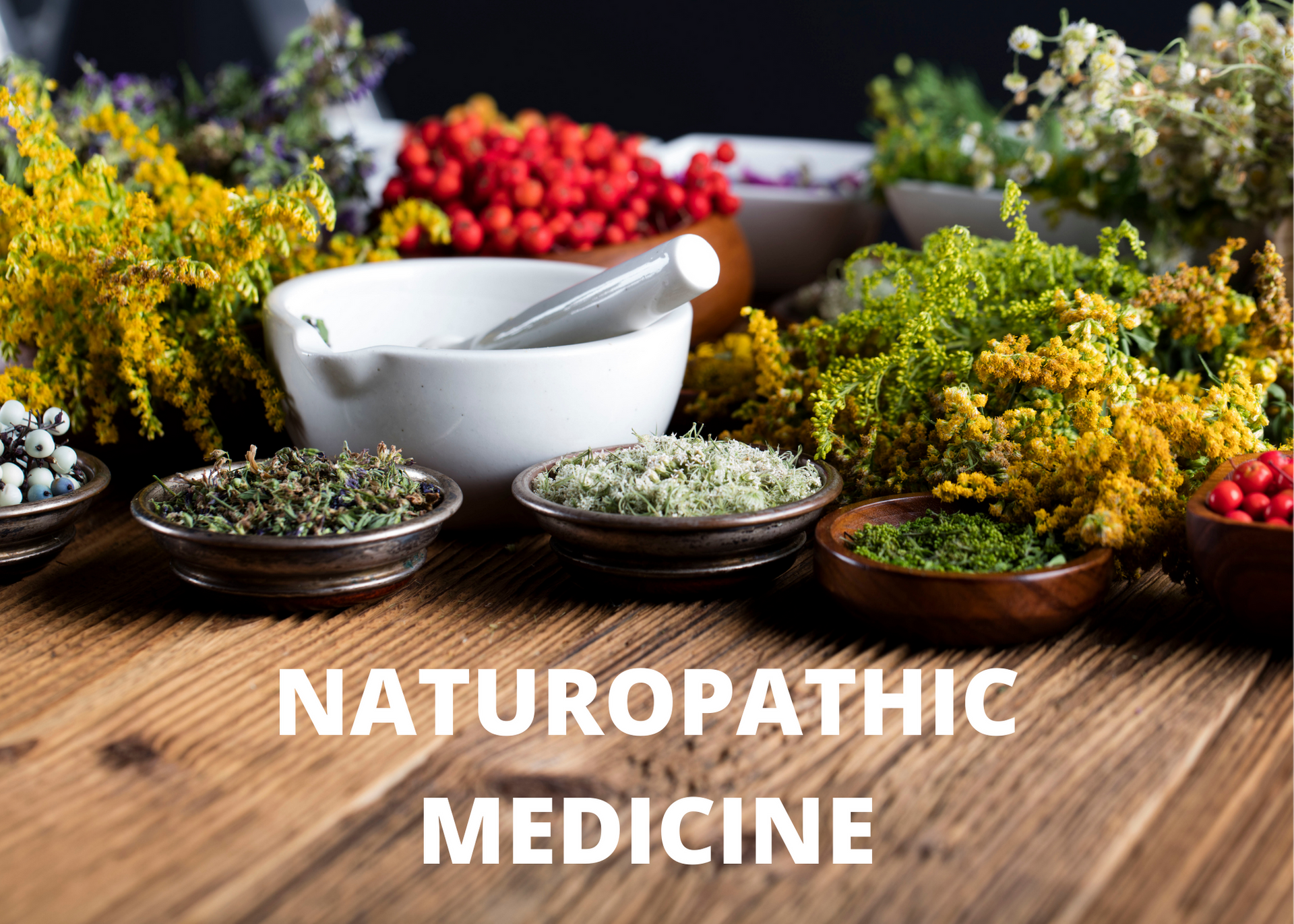 A wooden table topped with bowls of herbs and a mortar and pestle.