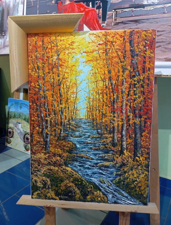 Dipinto a olio raffigurante un sentiero nel bosco con un ruscello, foglie dorate e cielo azzurro.