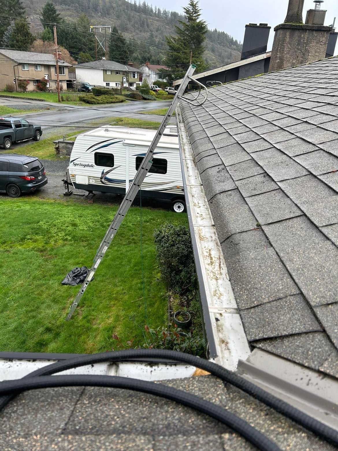 Clean photo of a gutter flushed out, ladder with stabilizers on it are included
