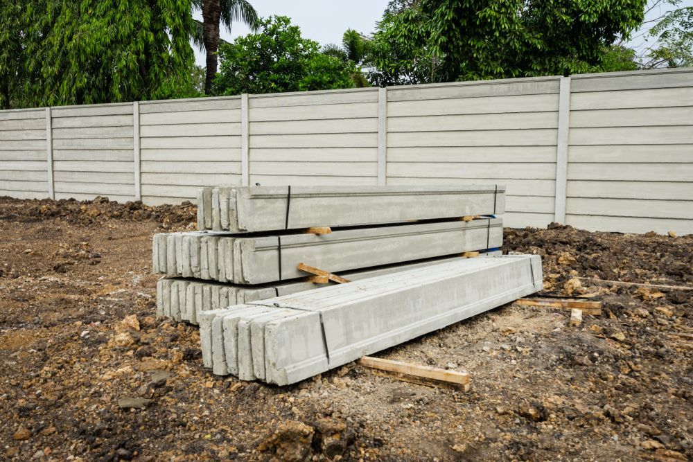 Concrete Fence Panels Stacked in Front of a Partially-built Concrete Fence — B&T Earthworks & Civil in Yorkeys Knob, QLD