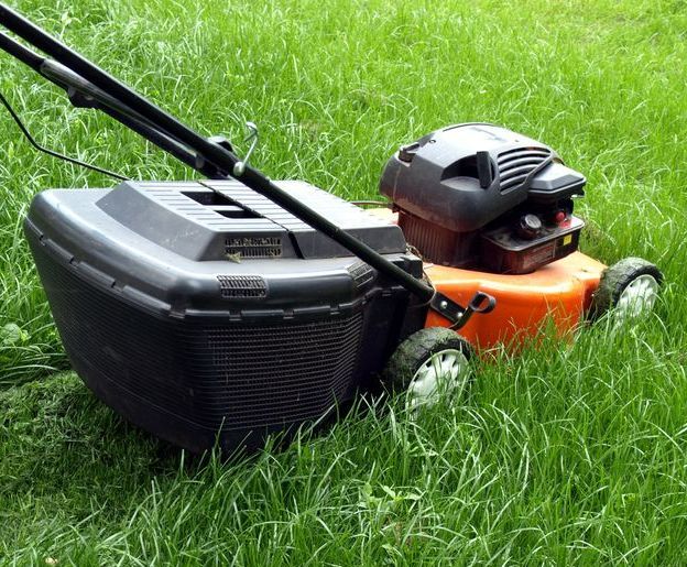 Lawnmower on Green Grass With Black Handle — B&T Earthworks & Civil in Bayview Heights, QLD