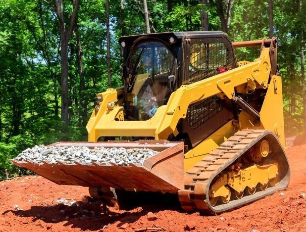 Yellow Track Loader Carrying Gravel on a Red Dirt Road — B&T Earthworks & Civil in Bayview Heights, QLD