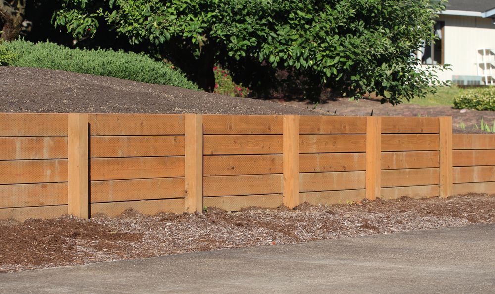 Wooden Retaining Wall With Vertical Posts and Horizontal Planks — B&T Earthworks & Civil in Gordonvale, QLD.