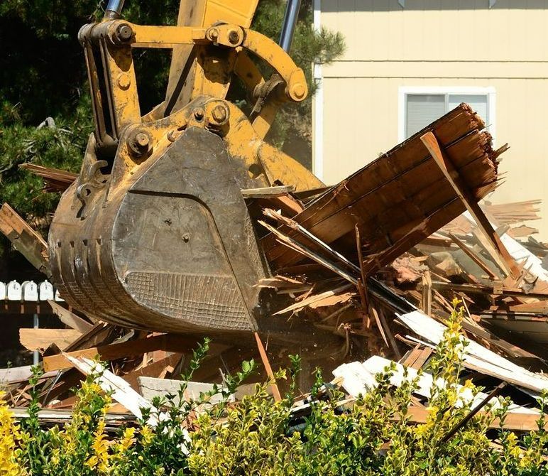 Yellow Excavator Demolishing a Building — B&T Earthworks & Civil in Smithfield, QLD