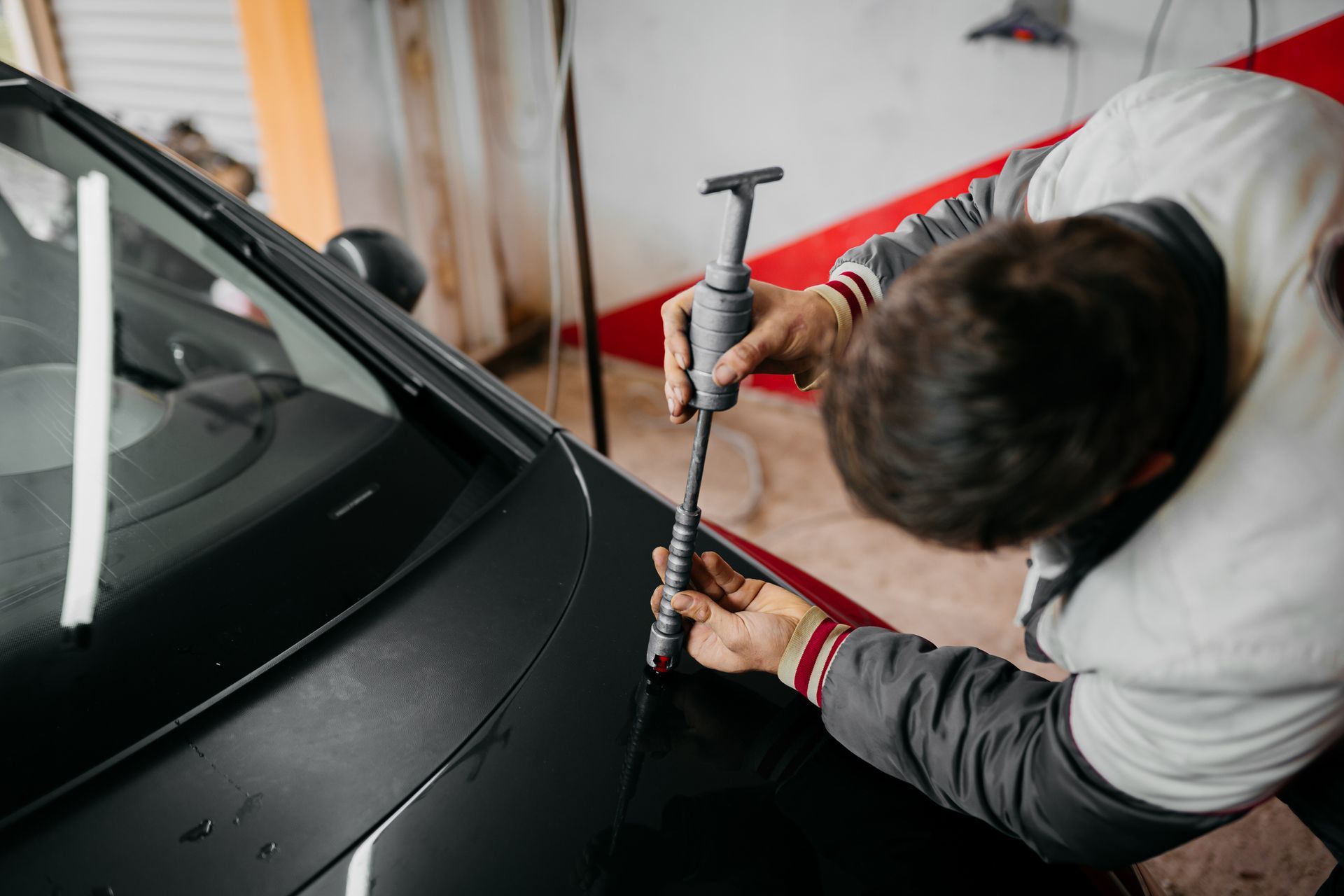 A man is working on a car in a garage.