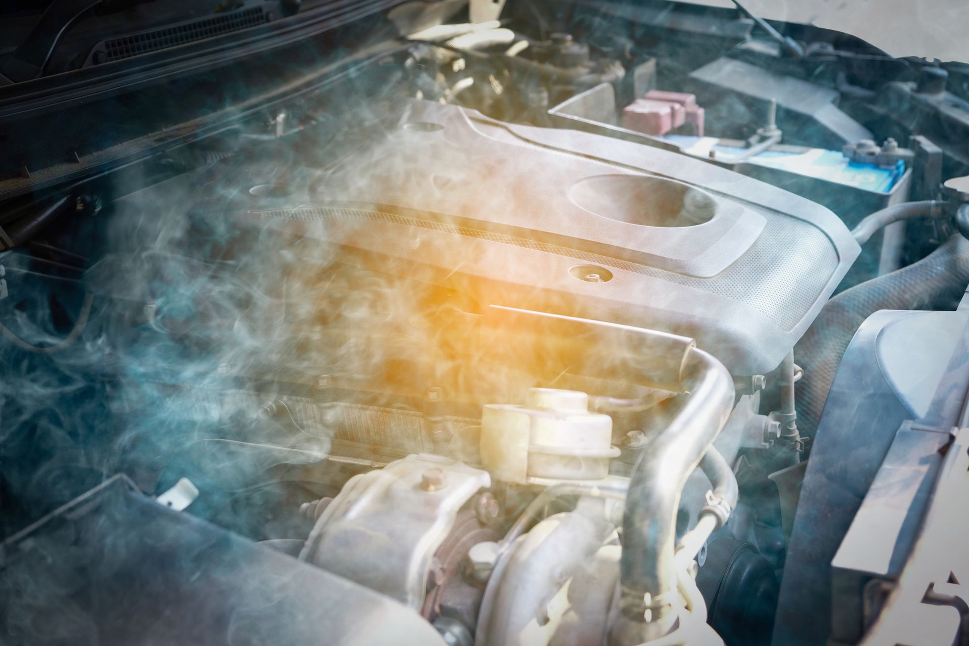 Smoke is coming out of the engine of a car.