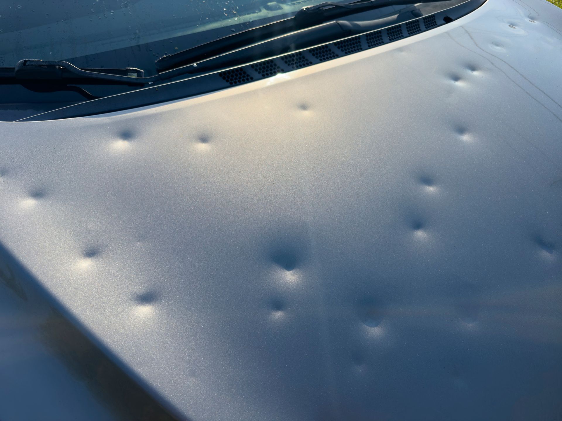 A close up of a car hood with holes in it