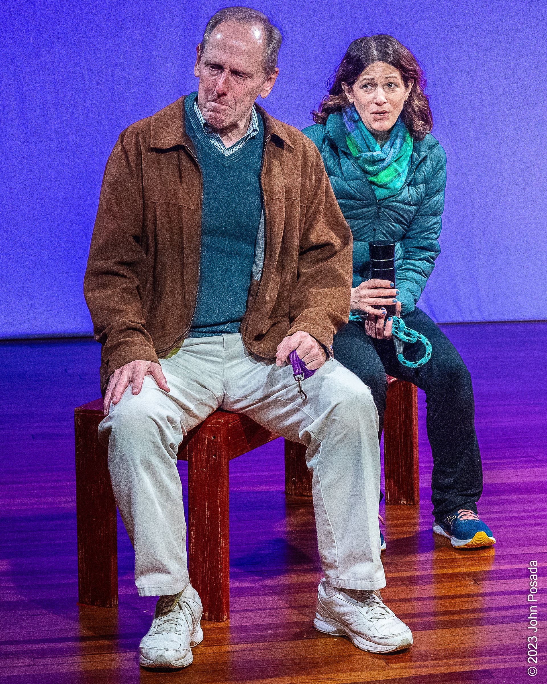 Two actors on a bench on stage