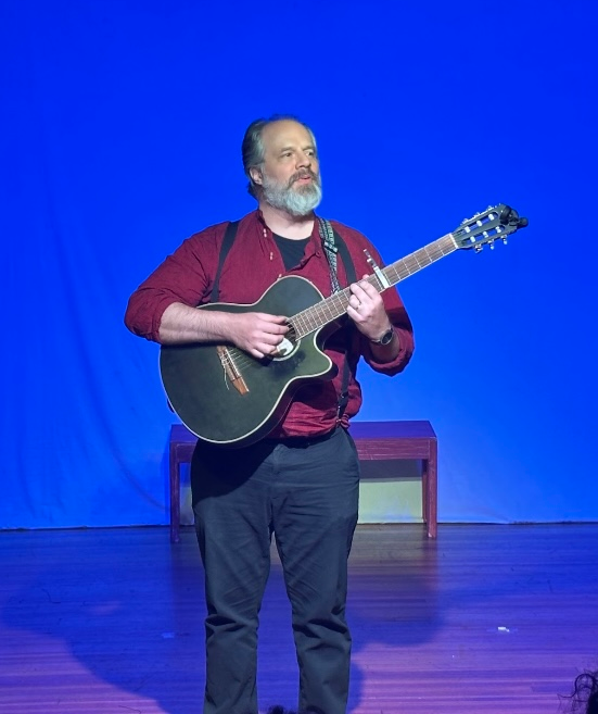 An actor playing the guitar