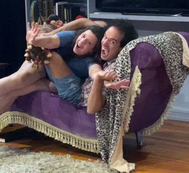 Two actors on a purple couch
