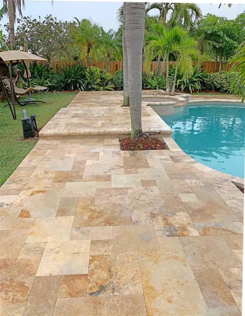 A swimming pool with a tiled walkway leading to it