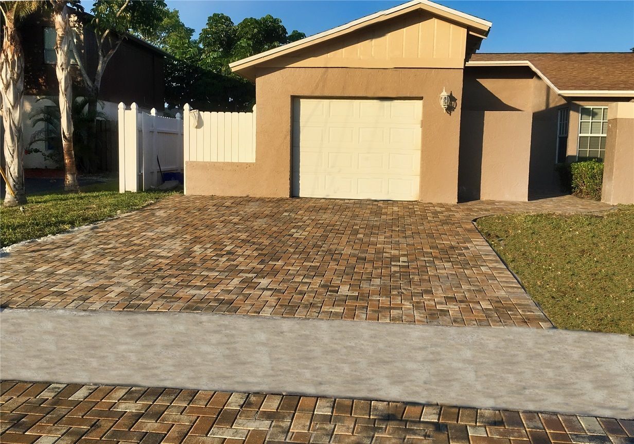 A house with a garage and a brick driveway