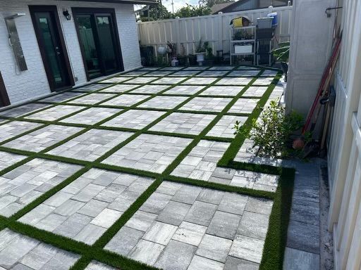 A patio with a lot of bricks and grass on it.