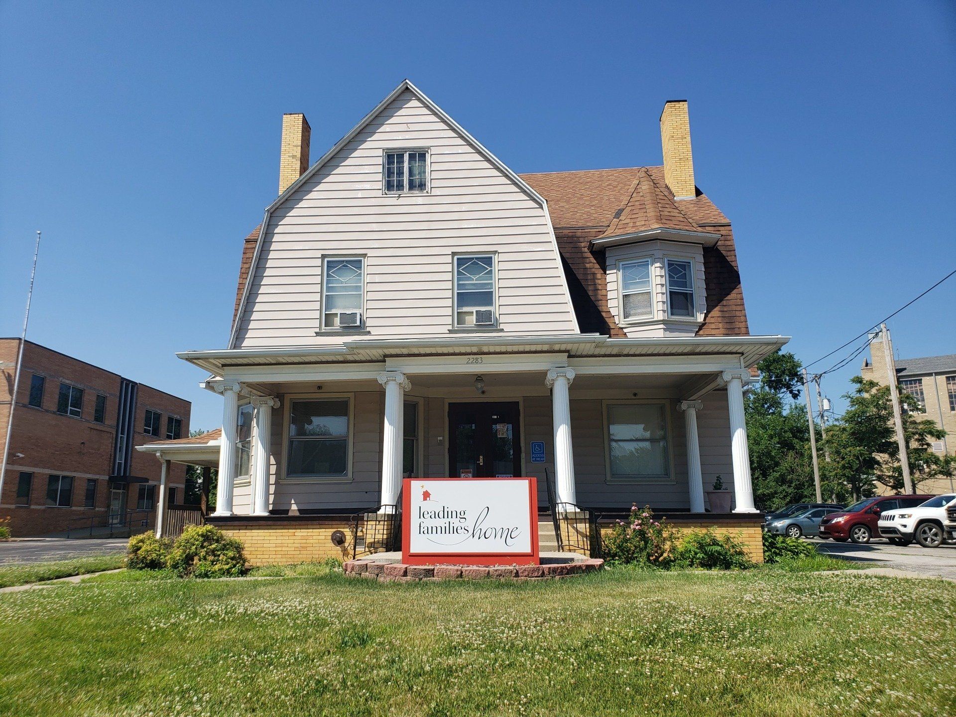 White house with porch, sign reading