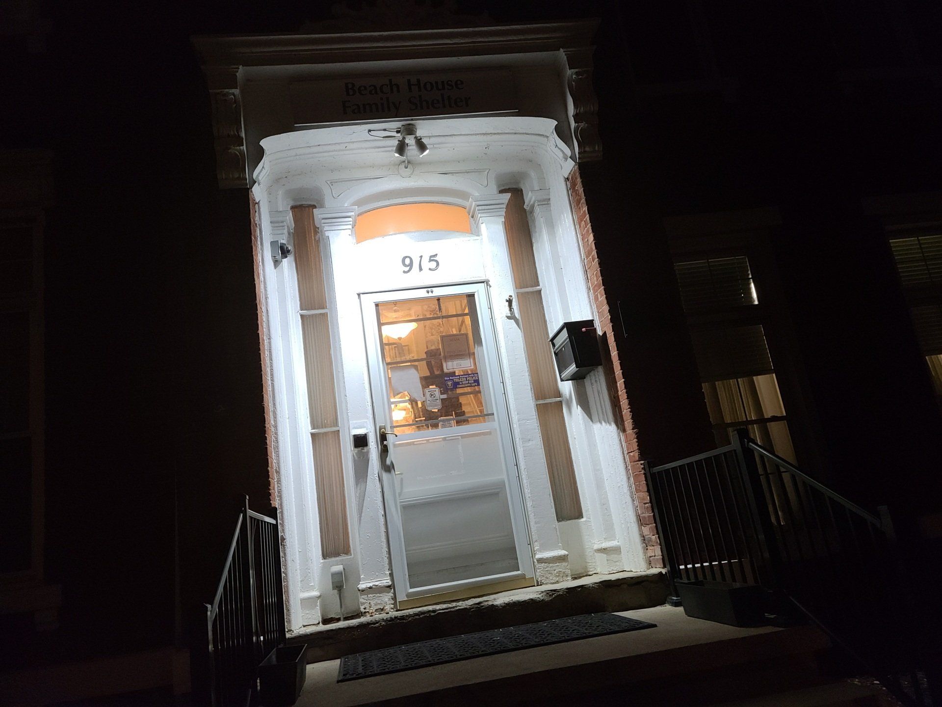 Lit doorway of building, with the number