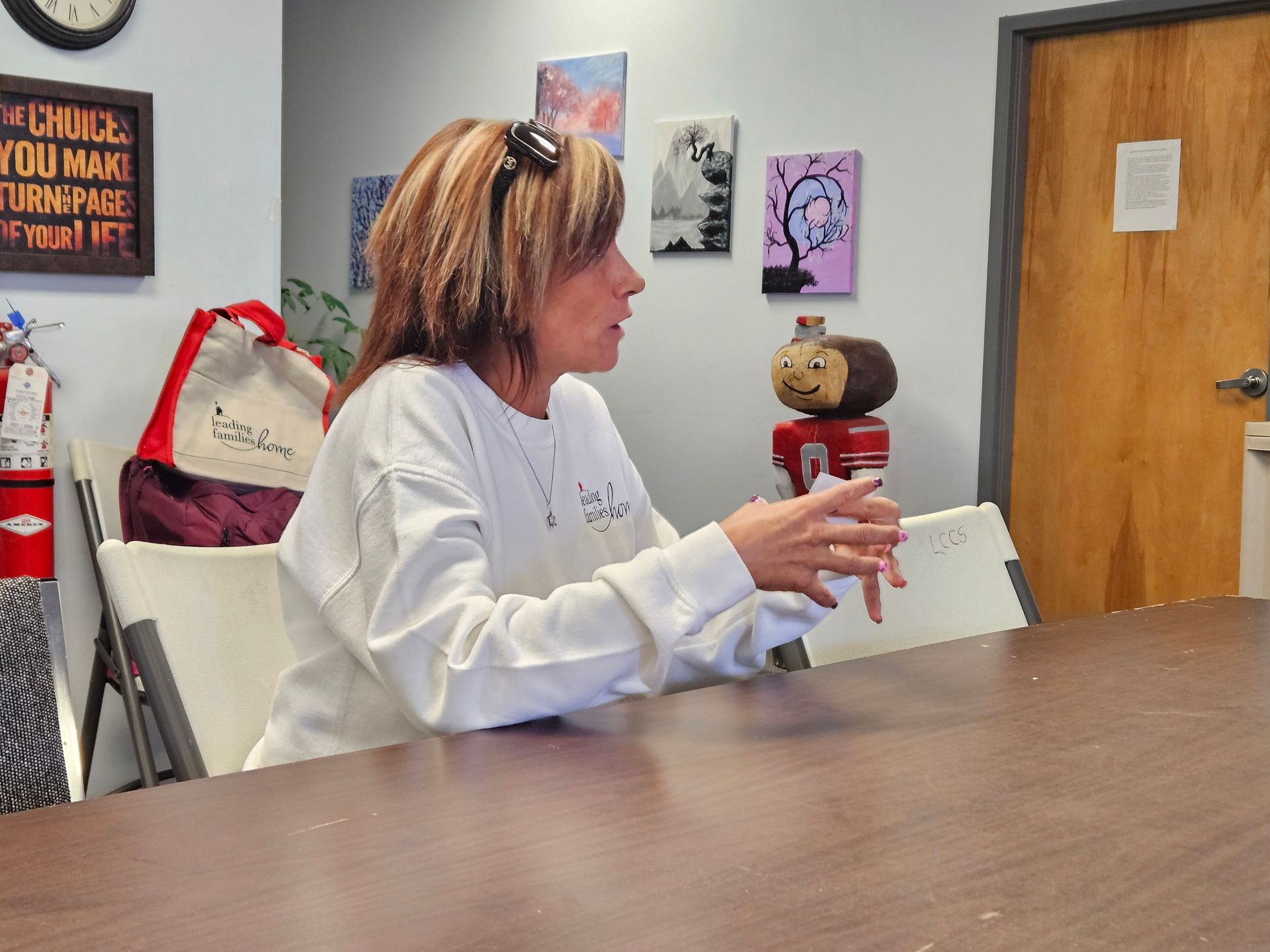 A woman sits at a table in front of a sign that says chill