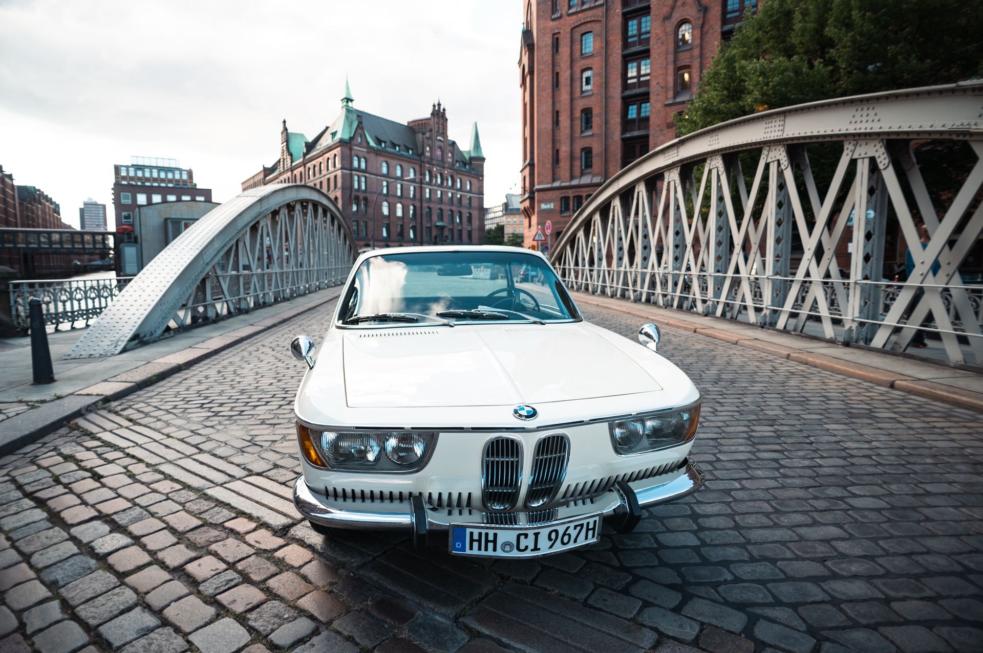 Weißer Oldtimer BMW auf einer Kopfsteinpflasterbrücke in Hamburg, Deutschland. Kirstin Hammerstein, hammerstein-pictures