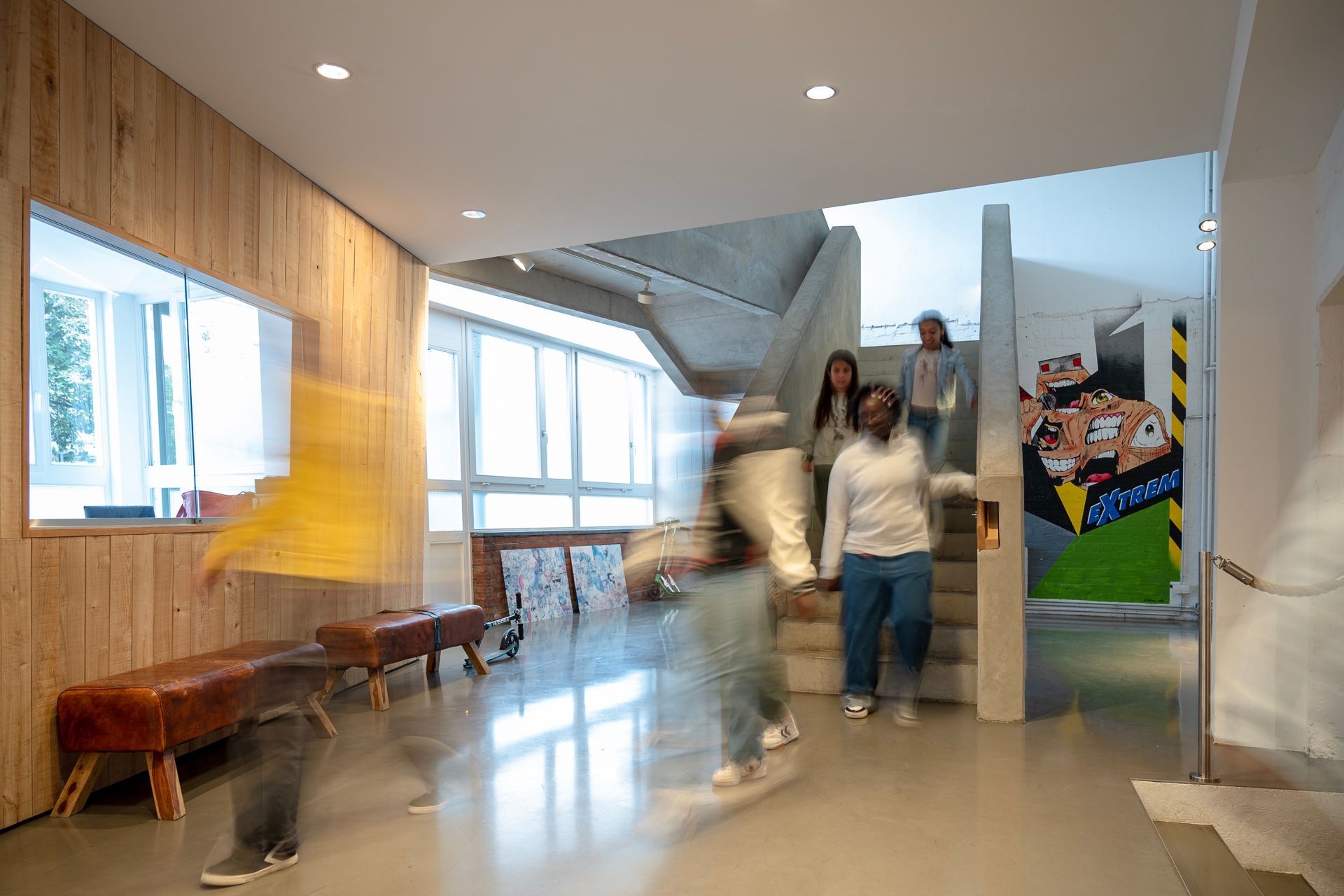Menschen gehen in einem modernen Gebäude mit Holzwänden und Treppe.