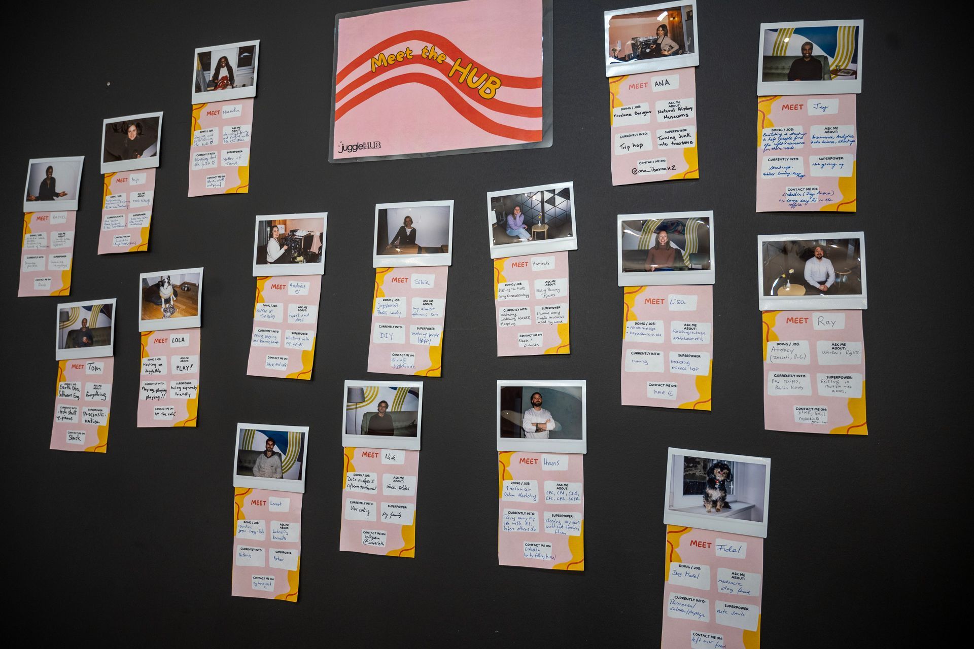 Fotos und Notizen hängen an einer dunklen Wand. Es wurde rosa und gelbes Papier verwendet.