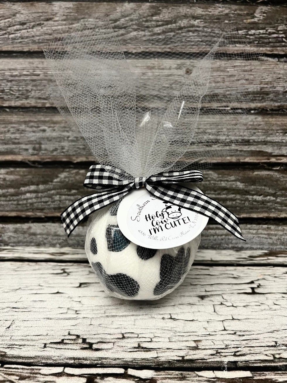 Black-and-white patterned ornament with ribbon and tag on a rustic wooden background