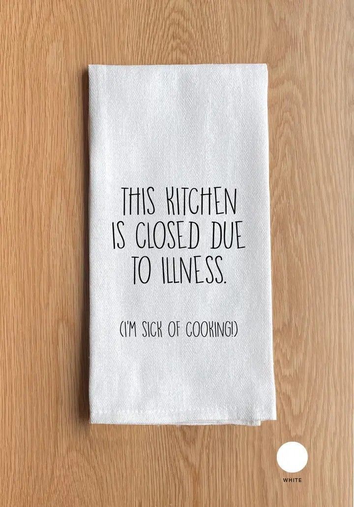 Small gray sign on a wooden surface reads, 