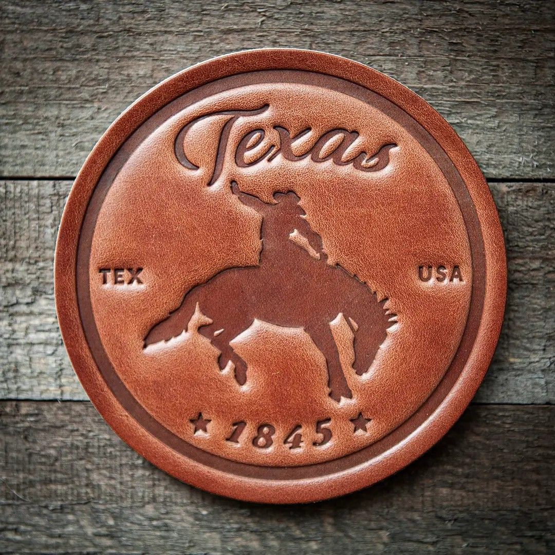 Round Texas souvenir medallion with state outline and “Texas” lettering on a rustic wood background